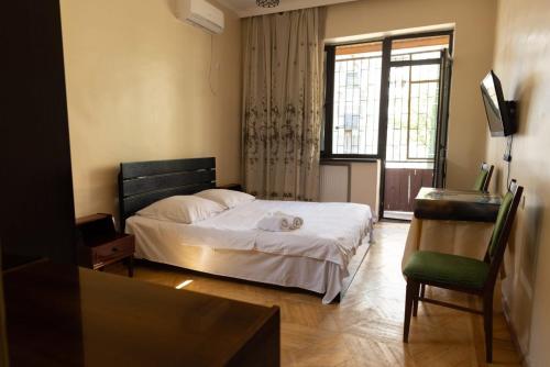a bedroom with a bed and a chair and a window at Wine House in Tbilisi City
