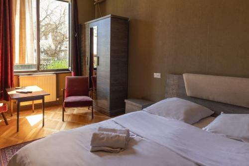 Schlafzimmer mit einem Bett, einem Tisch und einem Fenster in der Unterkunft Wine House in Tbilisi City