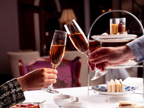 two people are holding wine glasses at a table at InterContinental Porto - Palacio das Cardosas by IHG in Porto