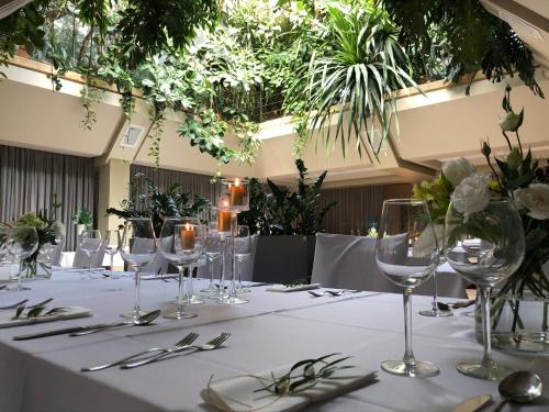 a table with wine glasses and silverware on it at Eurohotel Swarzędz in Swarzędz