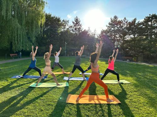 un grupo de personas haciendo una pose de yoga en la hierba en Eurohotel Swarzędz, en Swarzędz