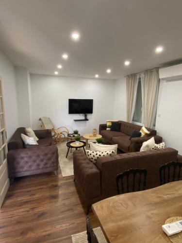 ein Wohnzimmer mit 2 Sofas und einem Flachbild-TV in der Unterkunft CASA RAHMA in Amboise