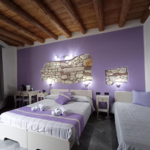 a bedroom with two beds and a stone wall at CQ Rooms Verona in Verona