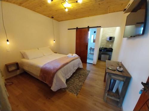 a bedroom with a bed and a table in it at Chalé dos Pellizzari in Monte Verde
