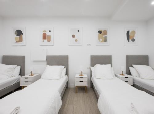 two beds in a room with white walls at No Limit Barcelona Central in Barcelona