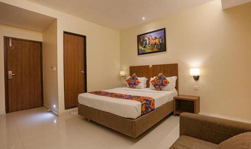 a hotel room with a bed and a couch at FabHotel Royal Mumbai International Airport in Mumbai