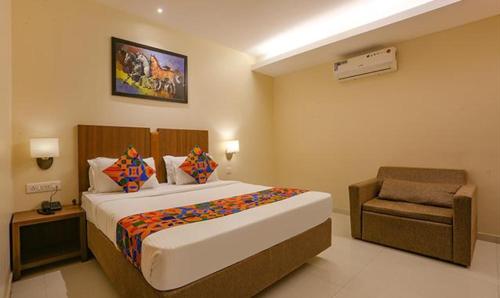 een slaapkamer met een groot bed en een stoel bij FabHotel Royal Mumbai International Airport in Mumbai