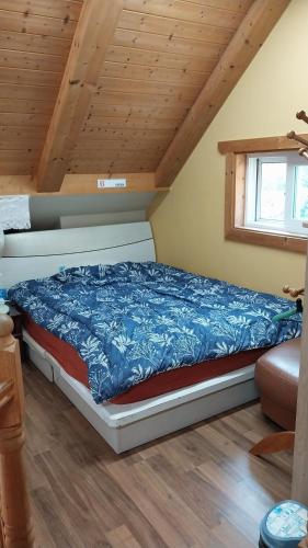 a bed in a room with a wooden ceiling at White House in Namhae