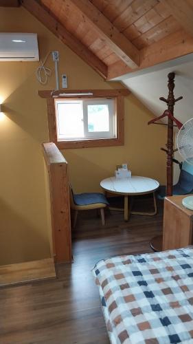 a room with a bed and a table and a window at White House in Namhae