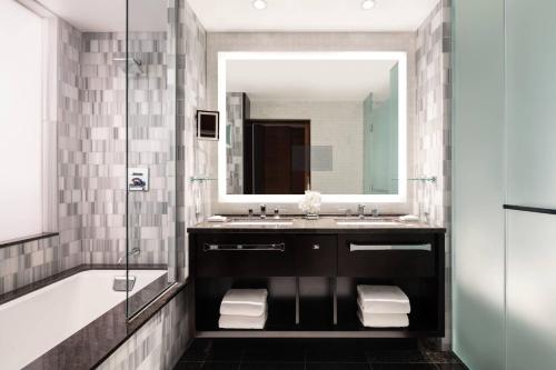 a bathroom with a sink and a tub and a mirror at The Ritz-Carlton, Los Angeles L.A. Live in Los Angeles