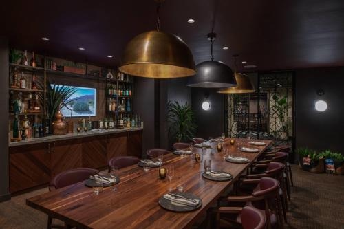 a long wooden table in a restaurant with chairs at The Ritz-Carlton, Los Angeles L.A. Live in Los Angeles