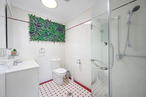 uma casa de banho com um WC, um lavatório e um chuveiro em Blacktown Renovated charming home & private yard em Blacktown