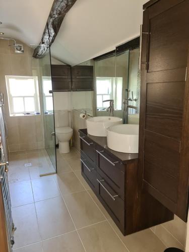 a bathroom with two sinks and a shower and a toilet at Home from home in Linton in Linton