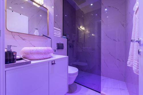 Baño púrpura con aseo y lavamanos en Altido Luxury Apartments, en Budva
