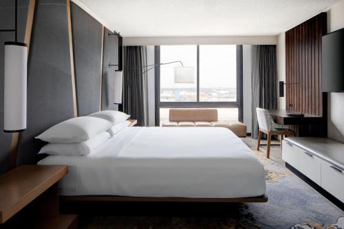 a bedroom with a large white bed and a desk at Houston Marriott South at Hobby Airport in Houston