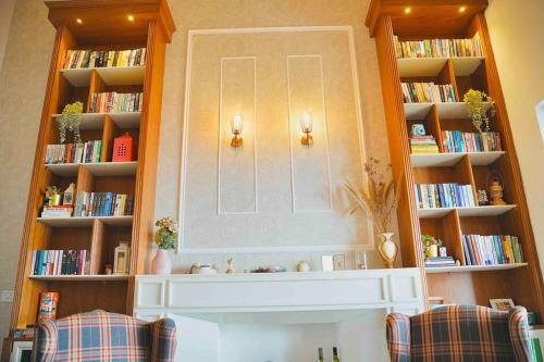 a fireplace in a room with book shelves with books at Leeladhar TranquilIty, Luxury Stone Villa in Theog
