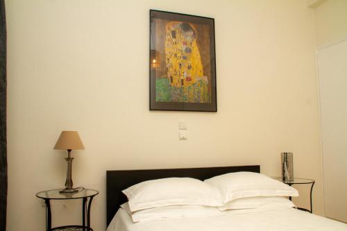 a bedroom with a bed and a painting on the wall at AQA - No4, 360 degrees photos of the apartment to know exactly what you are booking in Athens