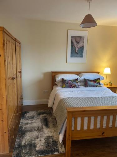 1 dormitorio con 1 cama con marco de madera en 360 Wolfe Stay, en Dungarvan