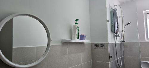 a bathroom with a round mirror and a shower at ER Homestay 2R1B suite nearby KLIA Terminal in Sepang