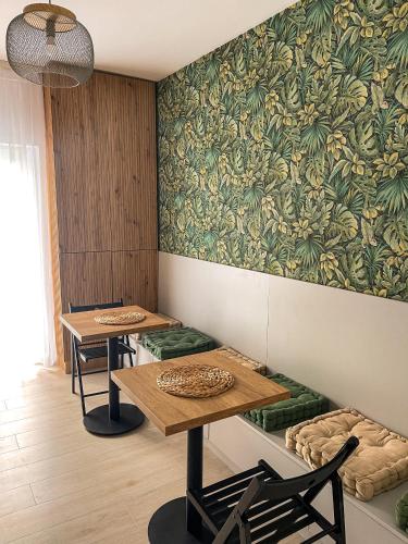 twee tafels en stoelen in een kamer met behang bij Casa Nis - Apartament 2 dormitoare in Sibiu in Turnişor