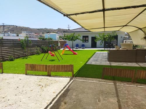 a backyard with a playground with a swing at Tzoli Residence in Kalamaki Heraklion