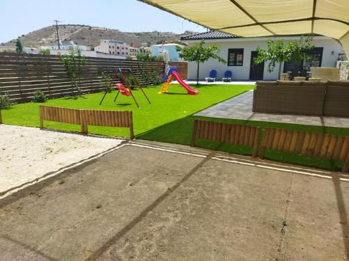 a backyard with a playground with a play area at Tzoli Residence in Kalamaki Heraklion