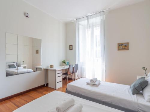 a bedroom with two beds and a desk and a mirror at The Best Rent - Spacious Two-bedroom apartment in Porta Romana in Milan