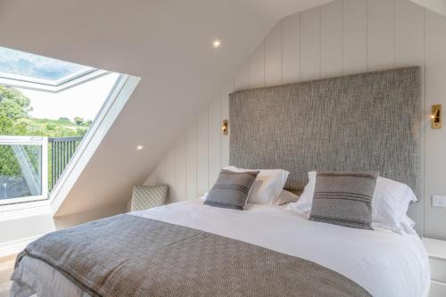 a bedroom with a large bed with a large window at Cranford in Salcombe