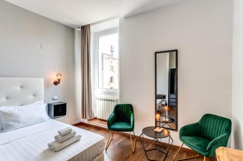 羅馬的住宿－Effe Luxury Palace，一间卧室配有一张床和两张绿色椅子