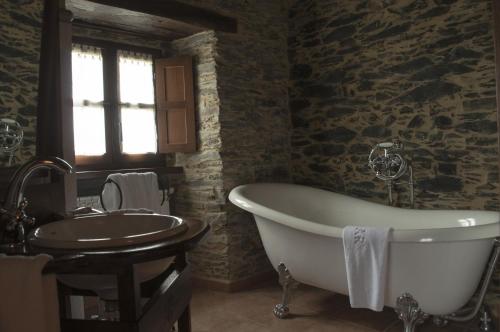 a bathroom with a bath tub and a sink at Apartamentos A Retoral in Coaña
