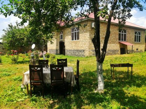 einen Tisch und Stühle vor einem Gebäude in der Unterkunft Fairy house in Qəbələ