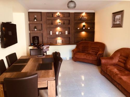 una sala de estar con una mesa y un sofá en LOVELY HOUSE BAKURIANI, en Bakuriani