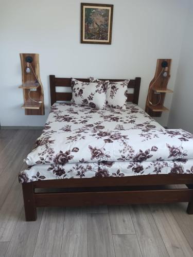 a bedroom with a bed with a floral bedspread at Cabana Trei Brazi Colibita in Colibiţa