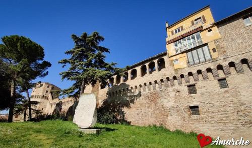 a large brick building with a tree next to it at Casa Rosetta Affittacamere in Iesi
