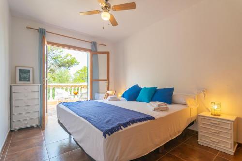 ein Schlafzimmer mit einem großen Bett mit blauen Kissen in der Unterkunft Villa Maria -Port des Canonge- in Port des Canonge 