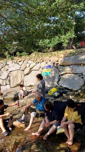 a group of people sitting on a rock wall at White House in Namhae