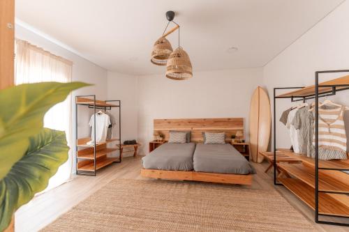 a bedroom with a bed and a surfboard at Eco Surflodge Azores in Ribeira Grande
