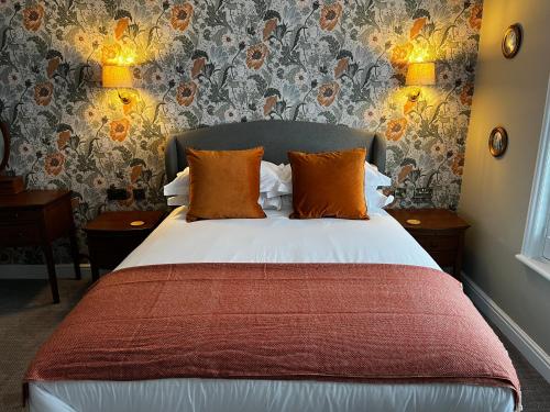 a bedroom with a large bed with orange pillows at The Crown Pub and Hotel in Manningtree