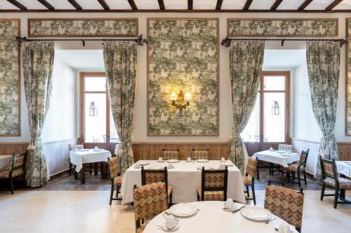 a dining room with tables and chairs and windows at Parador de Lerma in Lerma