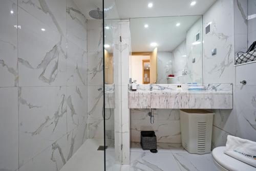 uma casa de banho com um chuveiro, um lavatório e um WC. em B19 - Marina Bay Apartment em Lagos