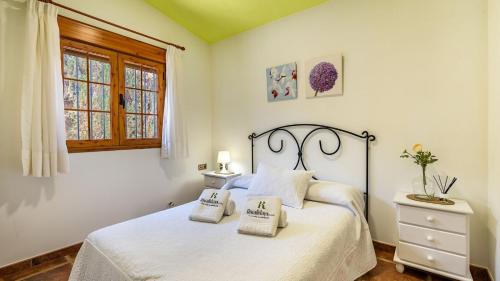 una camera da letto con un letto bianco con due cuscini sopra di Villa El Lote Salar by Ruralidays a Granada