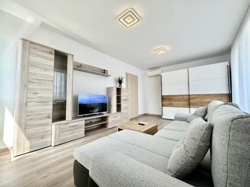 a living room with a couch and a tv at Urban Plaza Astra - Rise Private Apartments & Suites in Braşov