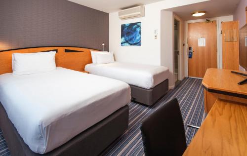 a hotel room with two beds and a desk at Holiday Inn Express Bristol City Centre by IHG in Bristol