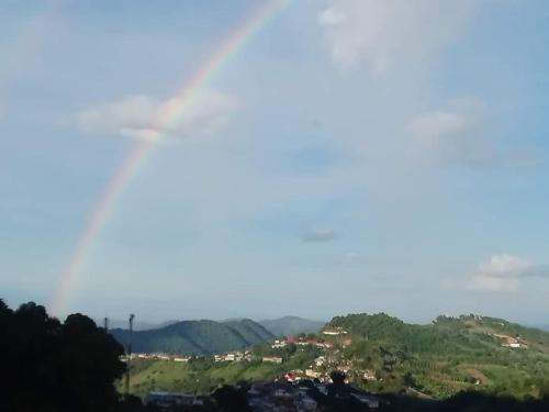 a rainbow in the sky over a city at Baan Ruam Cha in Mae Salong