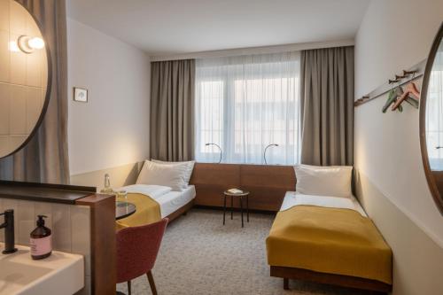 ein Hotelzimmer mit 2 Betten und einem Tisch in der Unterkunft magdas HOTEL Vienna City - First Social Business HOTEL in Austria in Wien