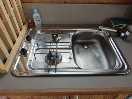 a stainless steel sink with a stove in it at Bateau logement nuit Insolite Astragale in Lège-Cap-Ferret