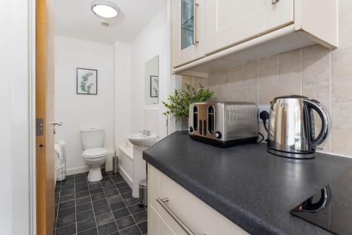 a kitchen with a counter top with a toaster and a toilet at Host Liverpool - Spacious Home for Family & Groups in Liverpool