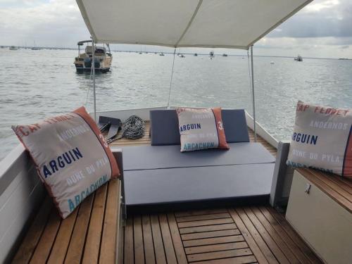 a boat with two pillows sitting on the deck at Bateau logement nuit Insolite Astragale in Lège-Cap-Ferret