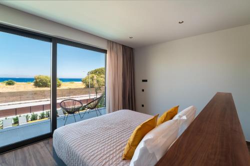 a bedroom with a bed and a large window at Momentum Villas in Ialysos