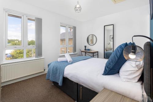 a bedroom with a bed and two windows at Host Liverpool - Spacious Home for Family & Groups in Liverpool